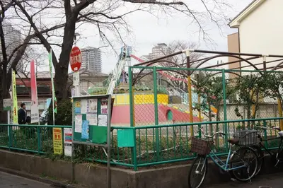 a bike parked next to a fence next to a playground at EK House SkyTree in Tokyo