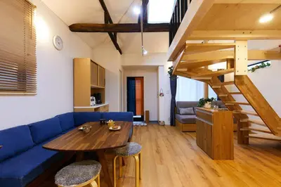 a living room with a blue couch and a wooden table at EK House SkyTree in Tokyo