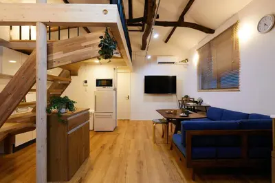 a living room with a blue couch and a table at EK House SkyTree in Tokyo