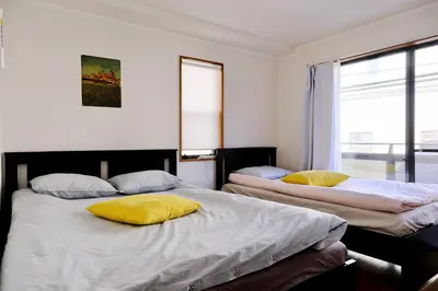 a bedroom with two beds with yellow pillows on them at Shinjuku/Kabukichō｜Super Busy Area｜Cozy House｜85㎡ in Tokyo