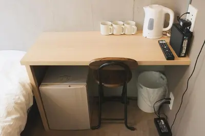 a wooden table with cups and a phone on it at Hotel Tabiya in Tokyo