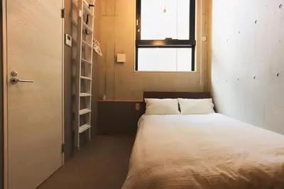 a small bedroom with a bed and a window at Hotel Tabiya in Tokyo