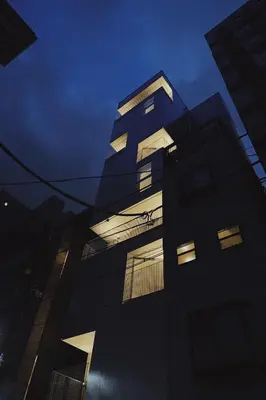 a tall building at night with lights on at Hotel Rakuragu in Tokyo