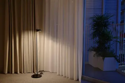 a floor lamp sitting next to a window with curtains at Hotel Rakuragu in Tokyo