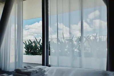 a bedroom with a window looking out at a plant at Hotel Rakuragu in Tokyo