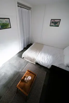 a bedroom with a bed and a table with flowers on it at Eden House in Tokyo