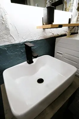 a white bathroom sink sitting on top of a counter at Eden House in Tokyo