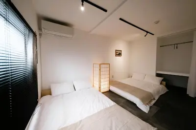 a bedroom with two beds and a window at Eden House in Tokyo