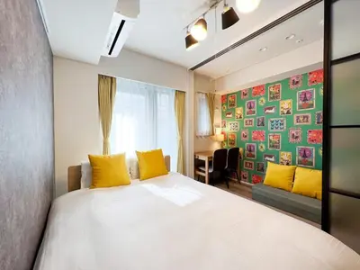 a bedroom with a bed with yellow pillows and a window at KISETSU\u65e9\u7a32\u7530l in Tokyo