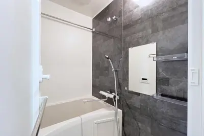 a bathroom with a tub and a shower with a mirror at KISETSU\u65e9\u7a32\u7530l in Tokyo