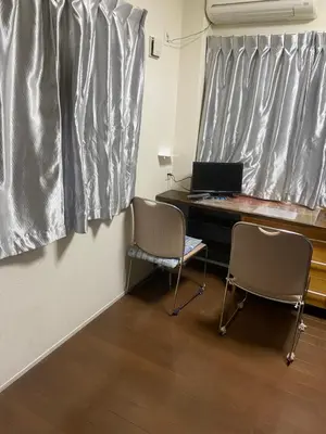 a room with a desk and two chairs and a laptop at \u65e5\u5149\u30d3\u30ebA or B in Tokyo