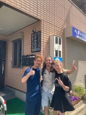 three people posing for a picture in front of a building at \u65e5\u5149\u30d3\u30ebA or B in Tokyo