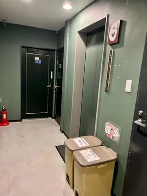 a hallway with green walls and a door and a stool at TenTen Guesthouse in Asakusa in Tokyo