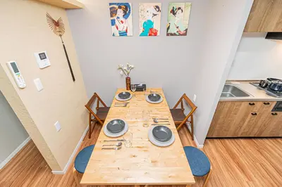 a long wooden table in a room with a kitchen at Ueno Park Asakusa Temple Ueno Family Inn in Tokyo