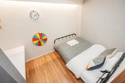 a bedroom with a bed and a clock on the wall at Ueno Park Asakusa Temple Ueno Family Inn in Tokyo
