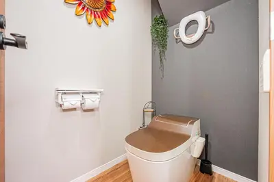 a bathroom with a toilet with a flower on the wall at Ueno Park Asakusa Temple Ueno Family Inn in Tokyo