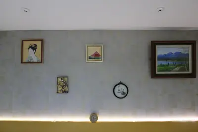 a wall with pictures and a clock on it at \u30a2\u30a4\u30ea\u30b9\u30b3\u30fc\u30c8 in Tokyo