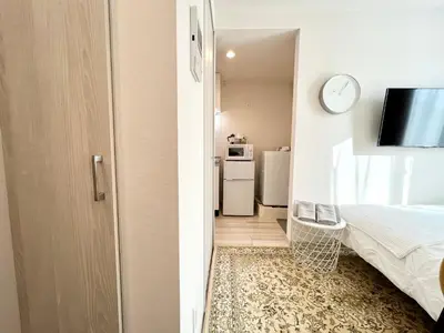 a small room with a bed and a refrigerator at TYO Ikebukuro Designer’s Apt 101 in Tokyo