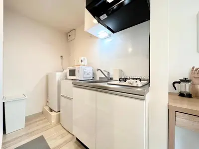 a kitchen with a sink and a white refrigerator at TYO Ikebukuro Designer’s Apt 103 in Tokyo