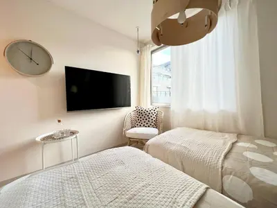 a bedroom with two beds and a clock on the wall at TYO Ikebukuro Designer’s Apt 103 in Tokyo