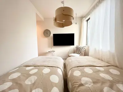a bedroom with two beds and a flat screen tv at TYO Ikebukuro Designer’s Apt 103 in Tokyo