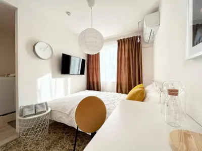 a bedroom with a bed and a table and a clock at TYO Ikebukuro Designer’s Apt 201 in Tokyo