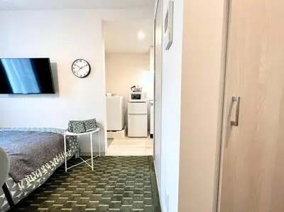 a room with a bed and a clock on a wall at TYO Ikebukuro Designer’s Apt 202 in Tokyo