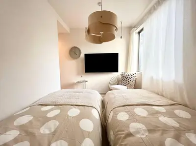 a bedroom with two beds and a flat screen tv at TYO Ikebukuro Designer’s Apt 203 in Tokyo
