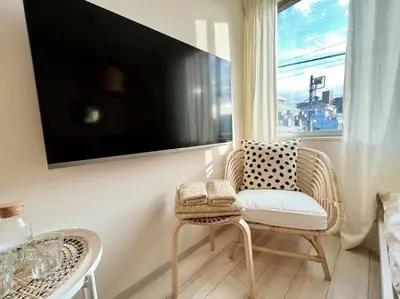 a living room with a chair and a television on a wall at TYO Ikebukuro Designer’s Apt 203 in Tokyo