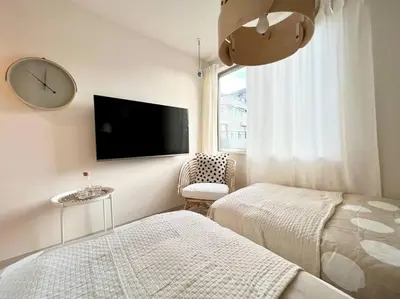 a bedroom with two beds and a clock on the wall at TYO Ikebukuro Designer’s Apt 203 in Tokyo