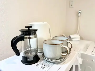 a coffee maker and two cups on a counter at TYO Ikebukuro Designer’s Apt 301 in Tokyo