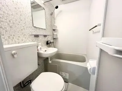a white bathroom with a sink and a toilet and a tub at TYO Ikebukuro Designer’s Apt 301 in Tokyo
