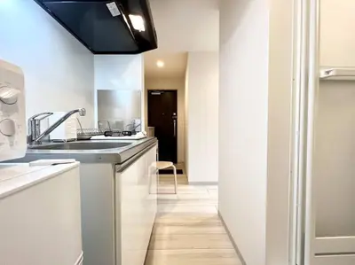 a white kitchen with a sink and a counter at TYO Ikebukuro Designer’s Apt 303 in Tokyo