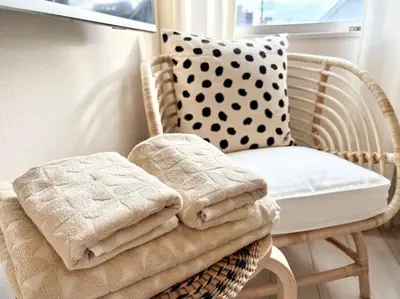 a wicker chair with a pillow and towels on it at TYO Ikebukuro Designer’s Apt 303 in Tokyo
