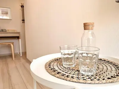 a table with two glasses and a bottle on it at TYO Ikebukuro Designer’s Apt 303 in Tokyo