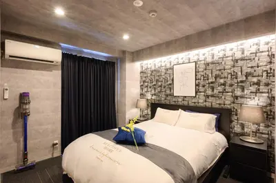 a bedroom with a large bed and a brick wall at RAKU Hotel Tokyo Bay Front in Tokyo