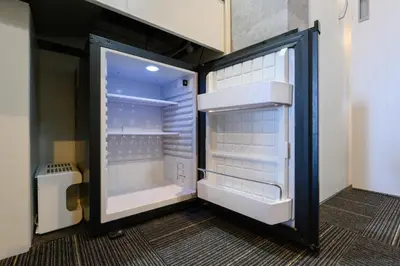 an empty refrigerator with its door open in a room at RAKU Hotel Tokyo Bay Front in Tokyo