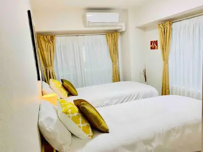 a bedroom with two beds with yellow and white pillows at Asakusa 2 Bedroom Apartment \u897f\u6d45\u83492LDK\u5e83\u3005\u30d5\u30a1\u30df\u30ea\u30fcor\u30b0\u30eb\u30fc\u30d7 in Tokyo