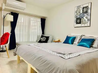 a bedroom with a large bed with blue pillows at Asakusa 2 Bedroom Apartment \u897f\u6d45\u83492LDK\u5e83\u3005\u30d5\u30a1\u30df\u30ea\u30fcor\u30b0\u30eb\u30fc\u30d7 in Tokyo