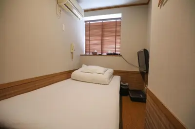 a small room with a bed and a window at \u30d7\u30c1\u30db\u30c6\u30eb\u3000\u30b3\u30b9\u30e2\u30b9 in Tokyo