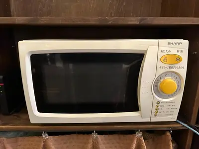 a white microwave oven sitting on a shelf at \u30d7\u30c1\u30db\u30c6\u30eb\u3000\u30b3\u30b9\u30e2\u30b9 in Tokyo