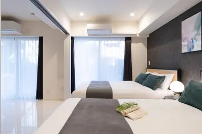 two beds in a hotel room with windows at CREAL premier\u8d64\u5742 in Tokyo