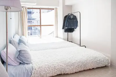 a bedroom with a white bed with a window at #8 3mins to station 1stop to Shinjuku Central Shinjuku apartment with plenty of Sunlight in Tokyo