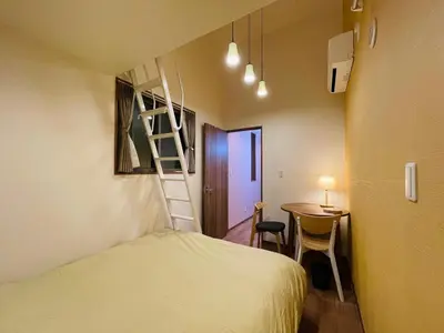 a small room with a bed and a table and a ladder at Asakusa，2BR Cozy Detached House，10mins to Sensō-ji in Tokyo