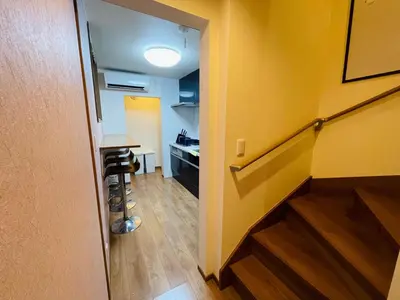 a hallway with a yellow wall and a desk and stool at Asakusa，2BR Cozy Detached House，10mins to Sensō-ji in Tokyo