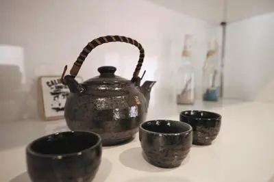 a group of three cups and a tea pot on a counter at self-check in-5mins walk from shinokubo station free wifi in Tokyo