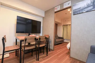a room with a table with chairs and a flat screen tv at self-check in-5mins walk from shinokubo station free wifi in Tokyo