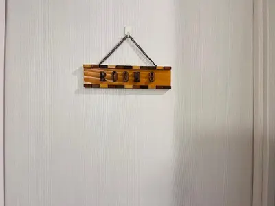 a wooden sign hanging on a white wall at \u6c60\u888bApila in Tokyo