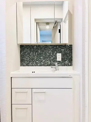 a white bathroom with a sink and a mirror at \u6c60\u888bApila in Tokyo