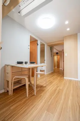 a dining room with a table and a wooden floor at Sakura Suite in Tokyo